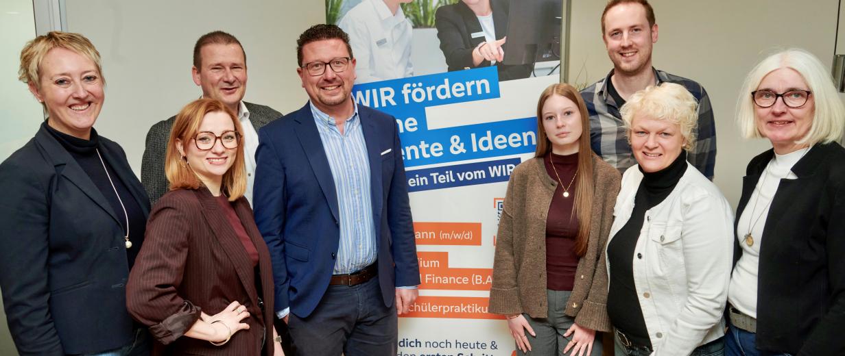 Gruppe von Personen vor Plakat