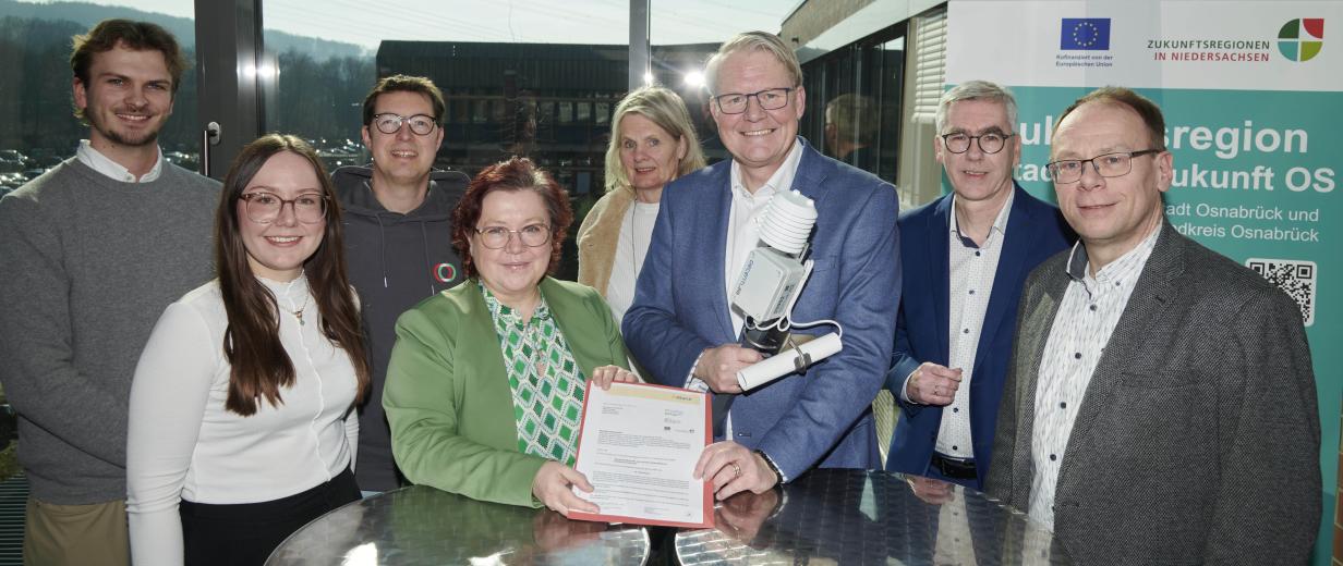 Personengruppe steht vor einem großen Fenster