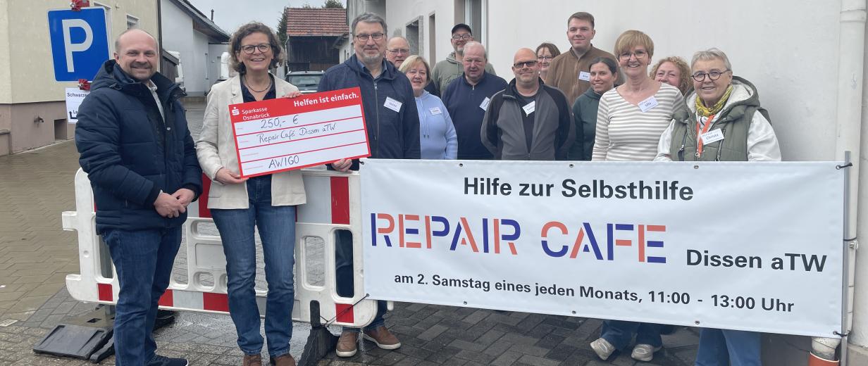 Personengruppe steht hinter einem Infobanner