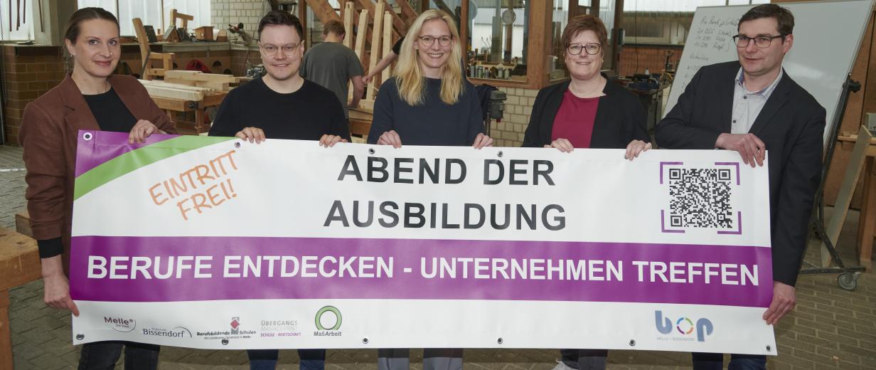 Fünf Personen stehen in einer Werkstatt.