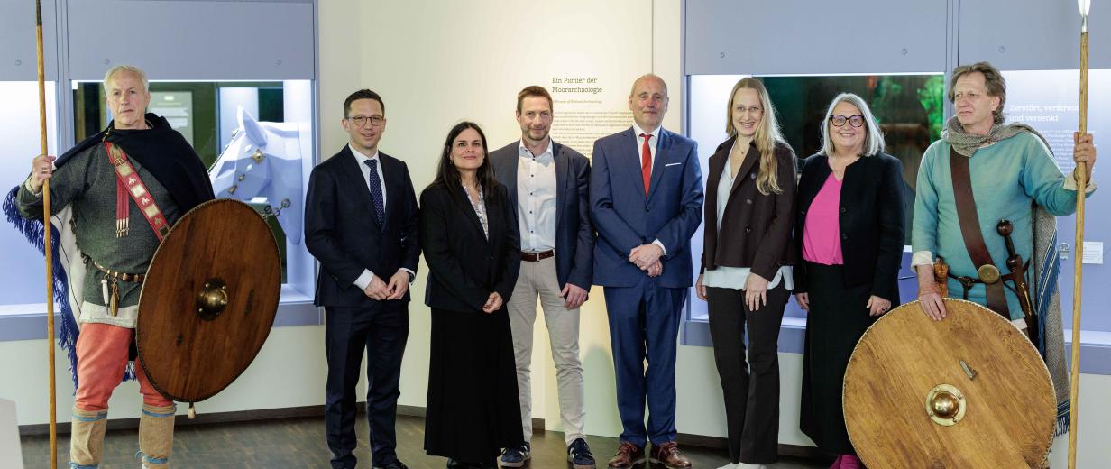 Eine Personengruppe steht in einer Ausstellung