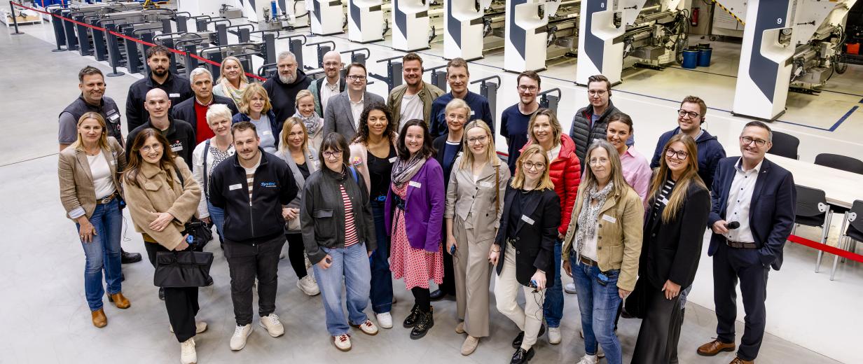 Personengruppe steht in einer Werkhalle