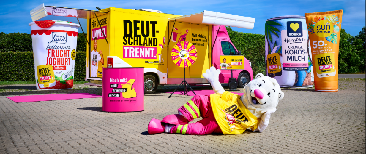 Showtruck auf einem Parkplatz mit überdimensionalen Verpackungen und einem Maskottchen