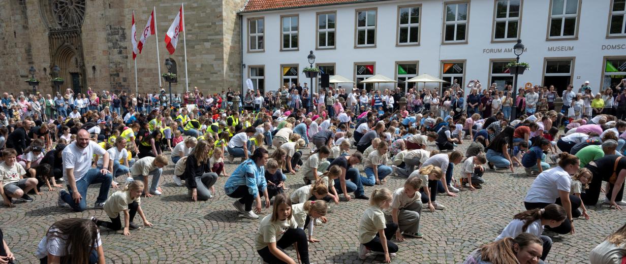Menschenmenge auf einem Platz, historische Gebäude im Hintergrund
