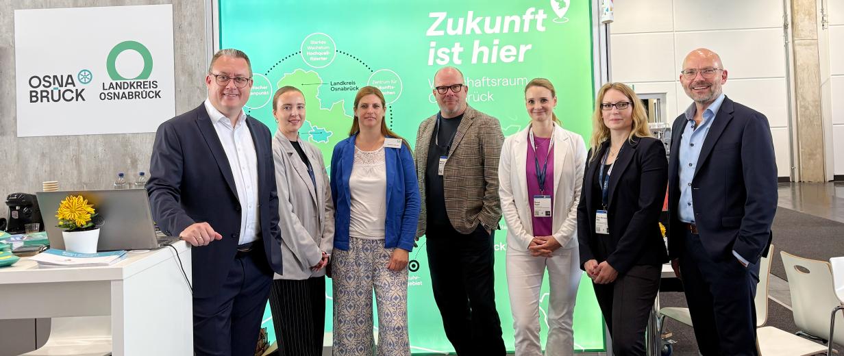Sieben Personen auf einem Messestand