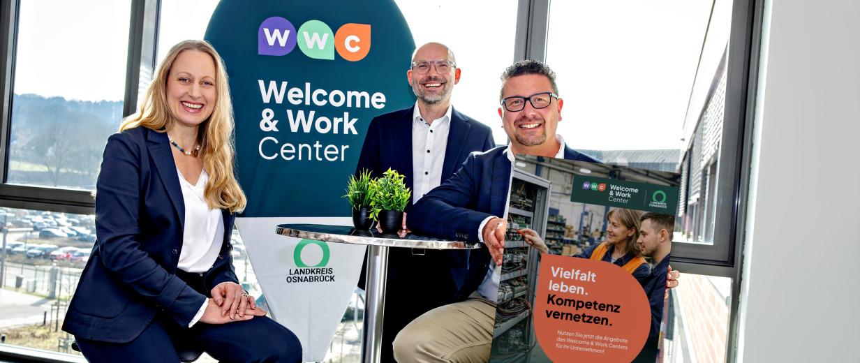 Drei Personen an einem Stehtisch
