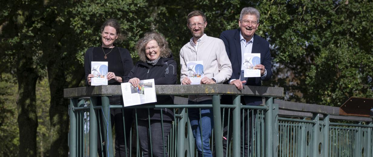 Vier Personen stehen auf einer Brücke.