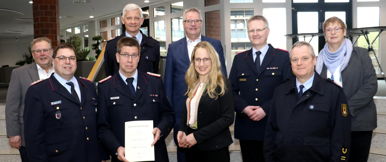 Gruppe von Feuerwehrleute (und Landrätin Kebschull) in einem Foyer