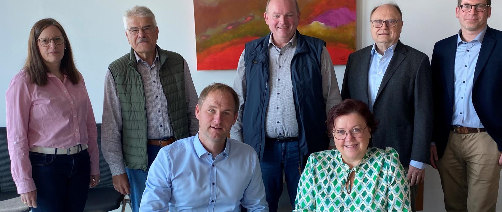 Gruppe vor Personen vor Schreibtisch