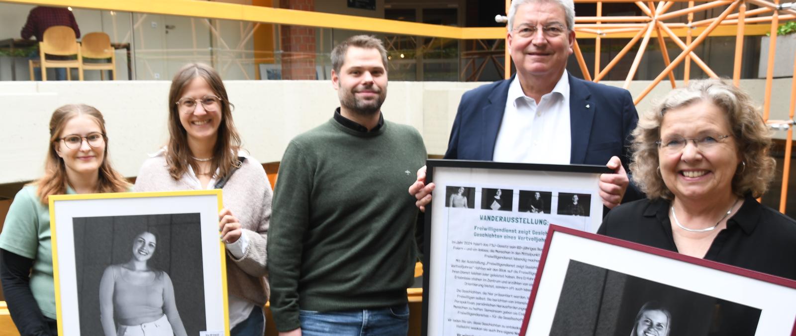 5 Personen mit Bild in der Hand