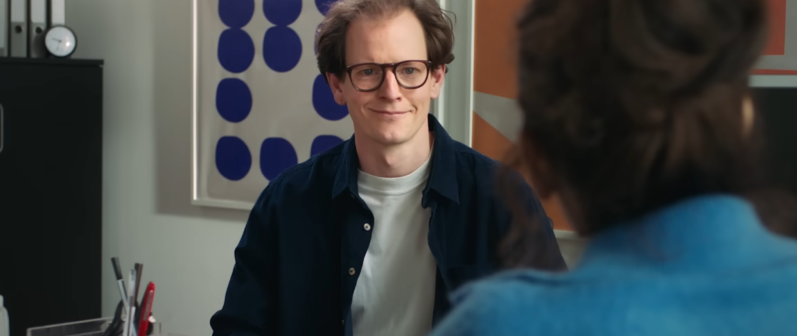 Zwei Personen sitzen sich in einem Büro gegenüber.