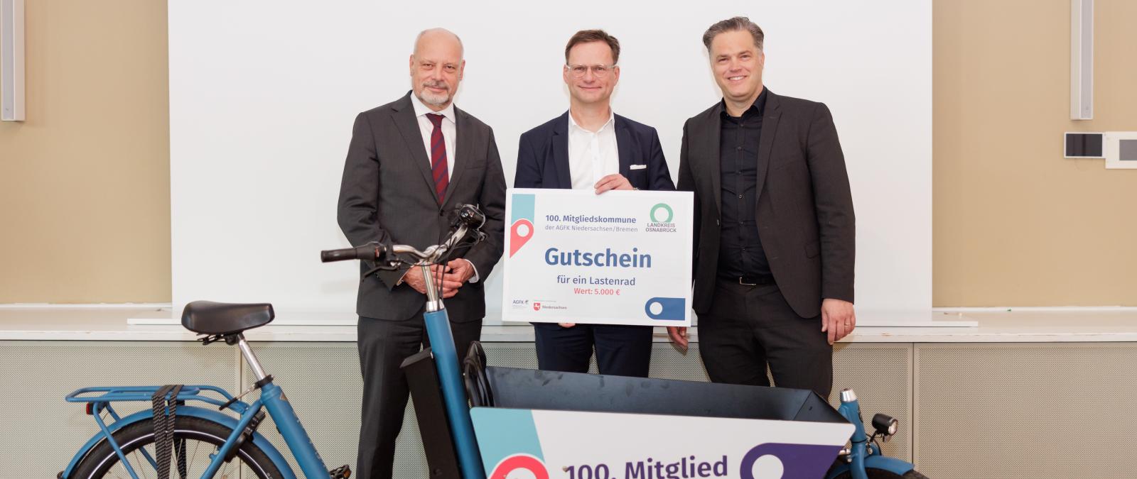 3 Personen vor Lastenrad