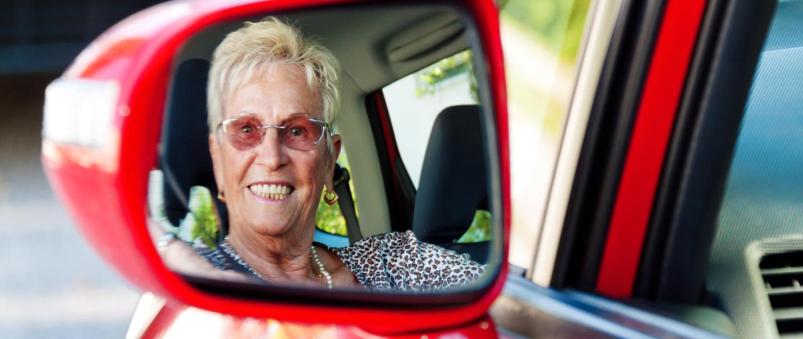 Frau im Seitenspiegel eines Autos