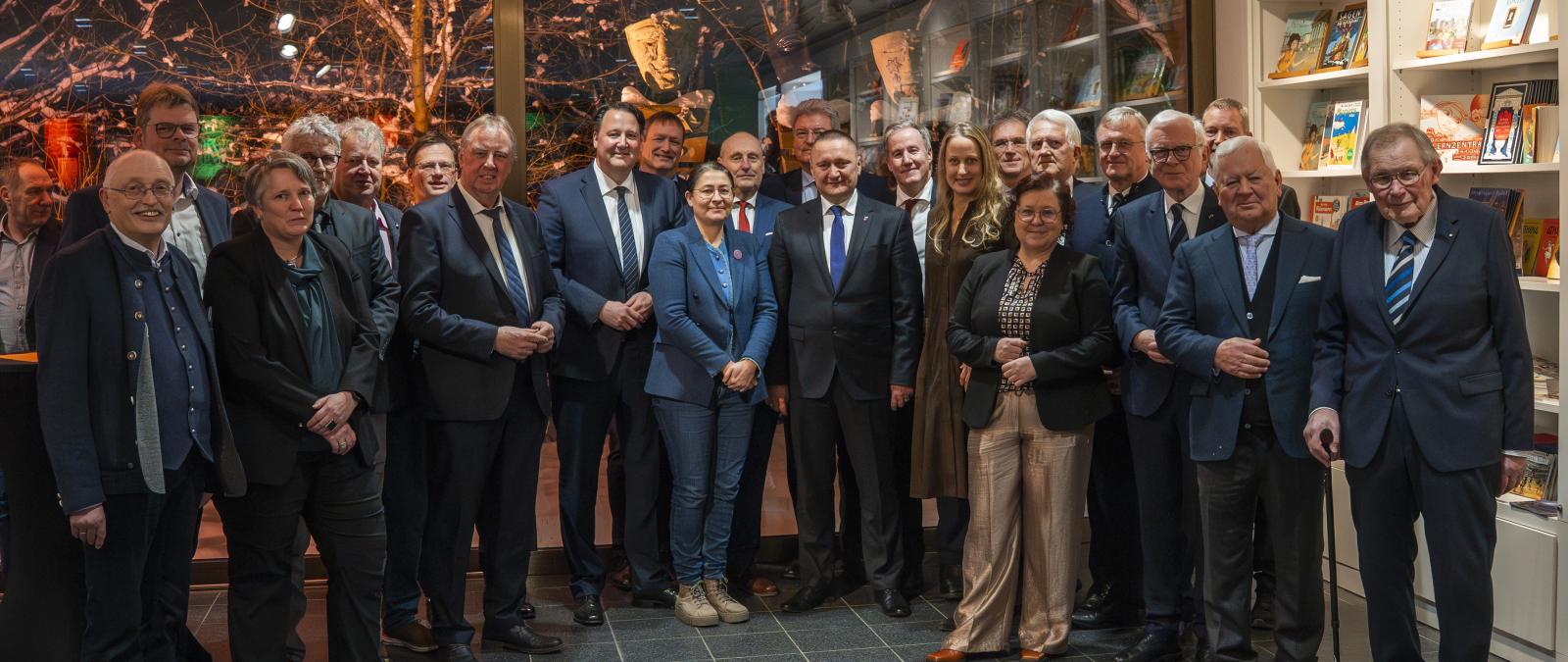 Eine Personengruppe steht in einem Foyer.