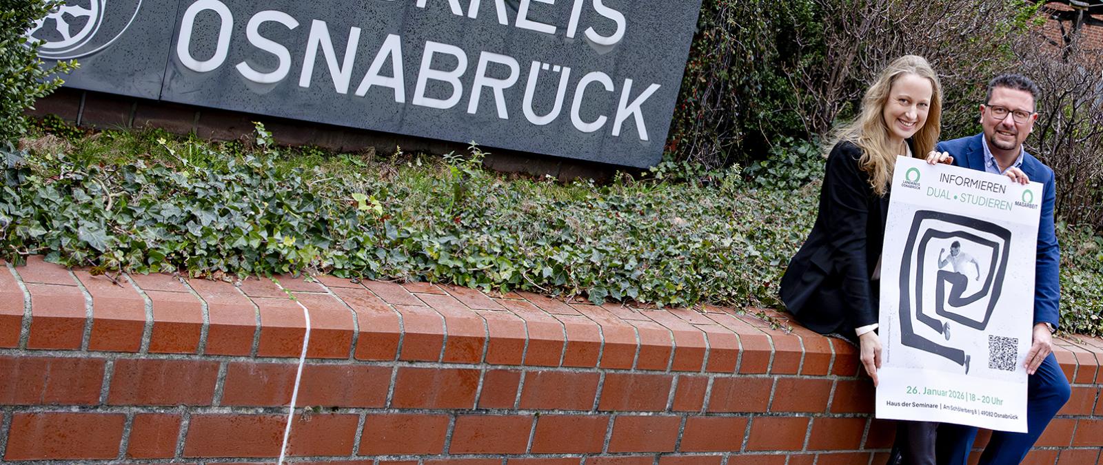 Landrätin und Maßarbeit-Vorstand Hellmers auf einer Mauer sitzend