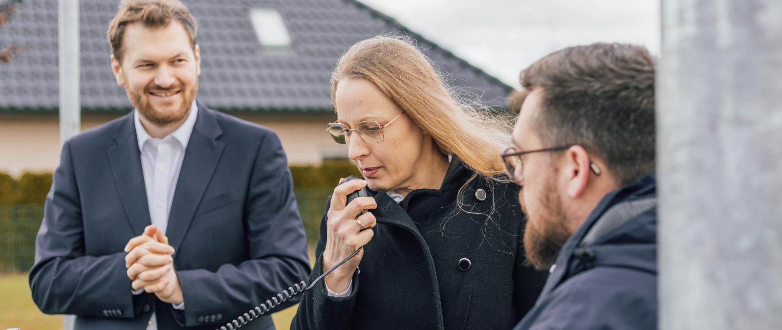 Drei Personen an einer Sirene