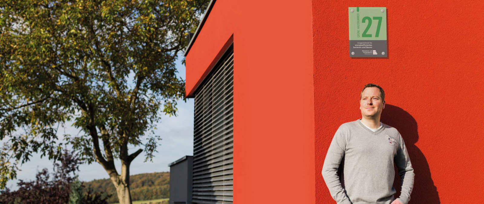 Mann an Hauswand lehnende