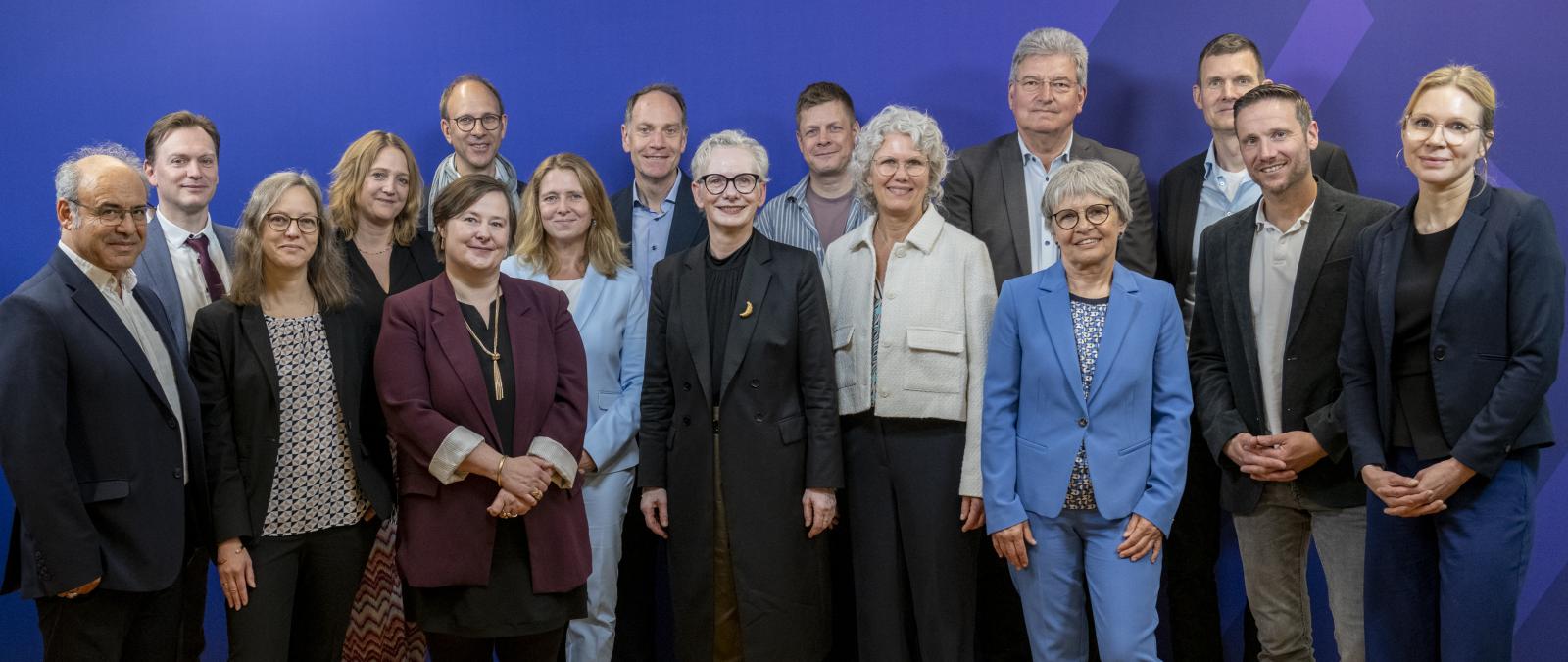 Personengruppe vor einem blauen Hintergrund