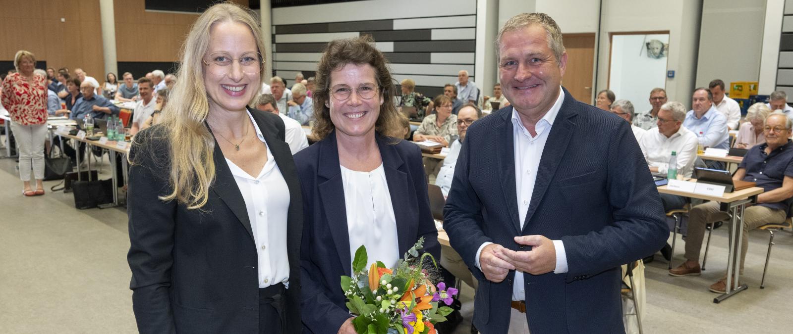 Drei Personen in einem großen Veranstaltungssaal