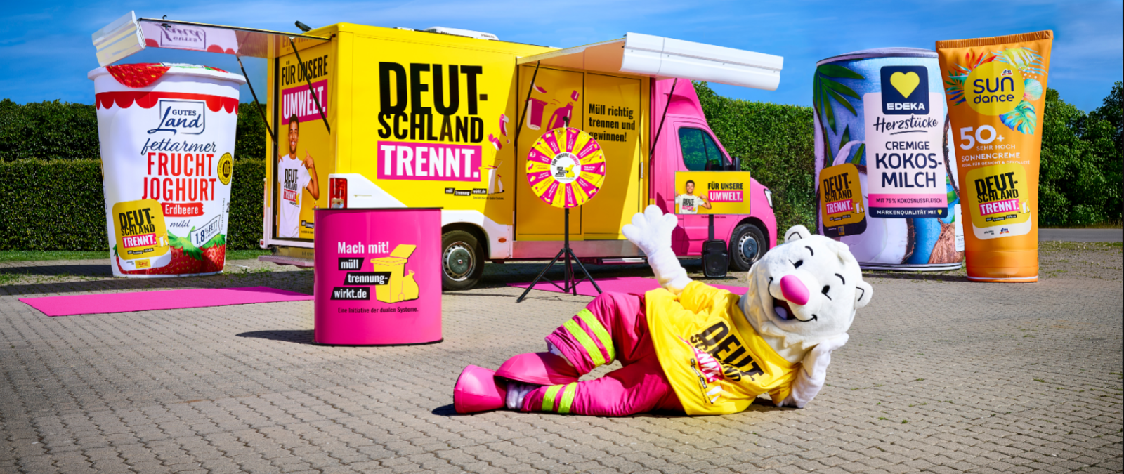 Showtruck auf einem Parkplatz mit überdimensionalen Verpackungen und einem Maskottchen
