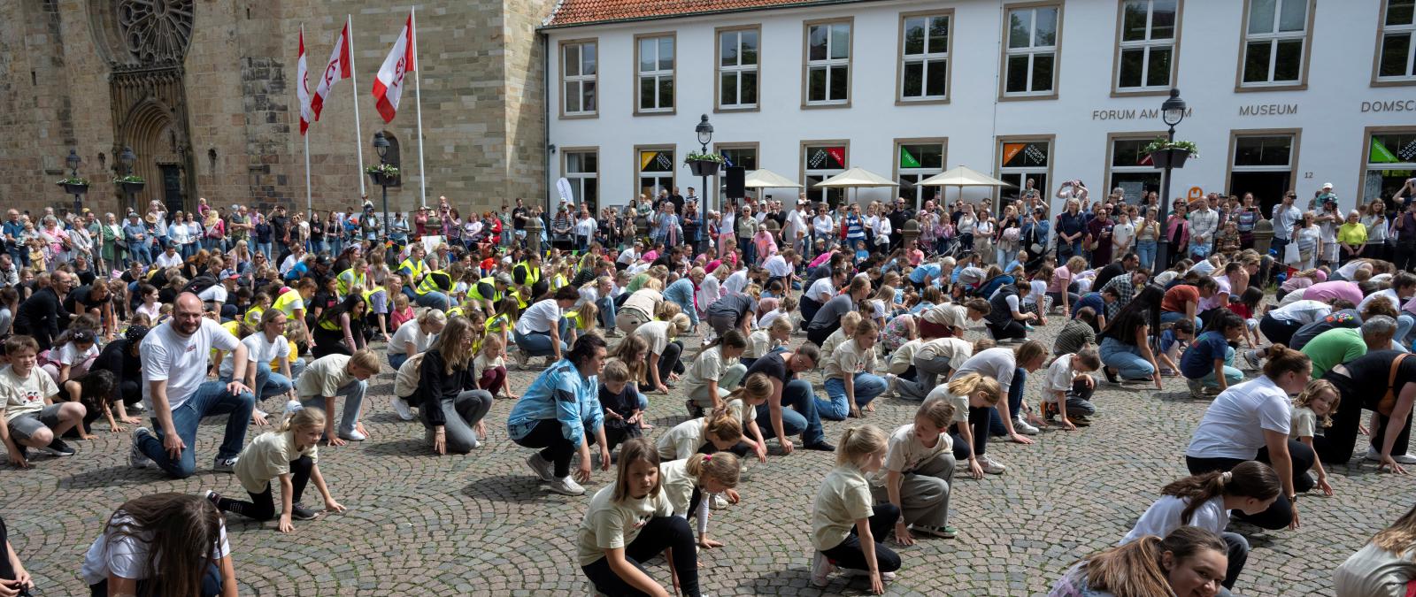 Menschenmenge auf einem Platz, historische Gebäude im Hintergrund