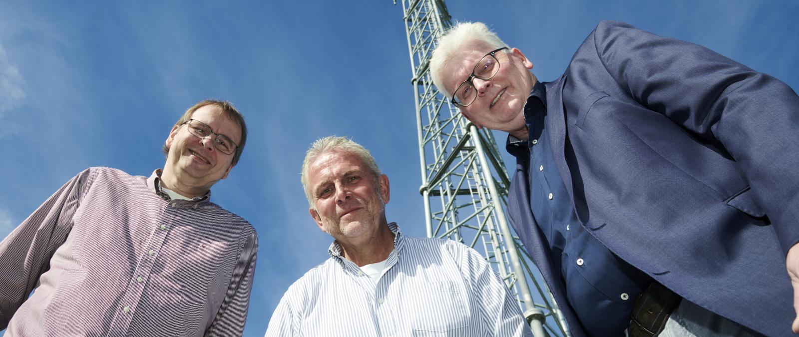 3 Personen blicken in Kamera