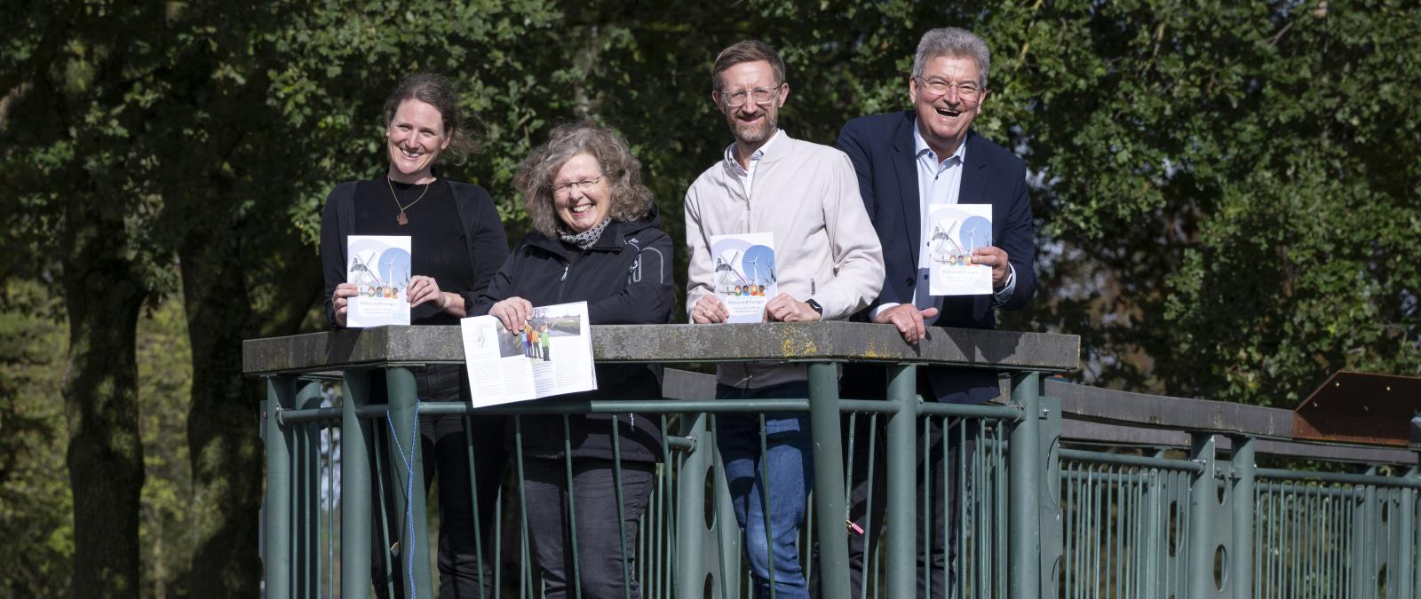 Vier Personen stehen auf einer Brücke.