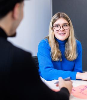 Zwei Personen sitzen sich schräg gegenüber.