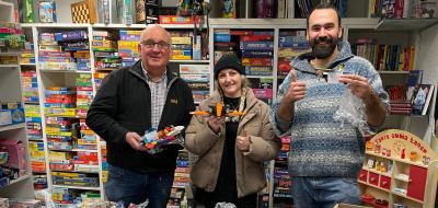 3 Personen vor Lego-Tüten stehend