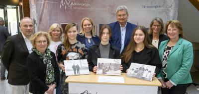 Gruppe von Personen vor Stellwand