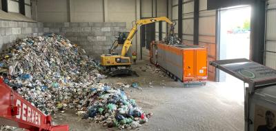 Innenansicht einer Lagerhalle mit Bagger und LKW