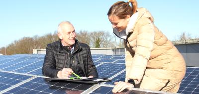 Zwei Personen zwischen Solaranlagen