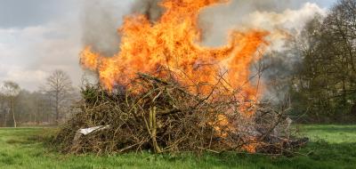 brennender Holzhaufen auf einer Wiese