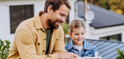 Zwei Personen stehen vor einem Einfamilienhaus