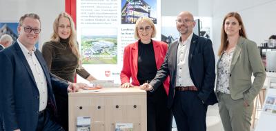 5 Personen vor Messestand