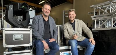 Zwei Personen sitzen auf Bühnentechnik-Elementen.