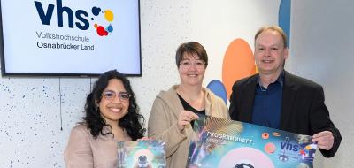 3 Personen mit Plakat