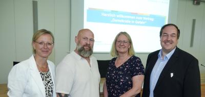 4 Personen vor Powerpoint-Folie