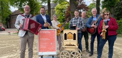 Sieben Personen mit Musikinstrumenten stehen auf einem Hof.