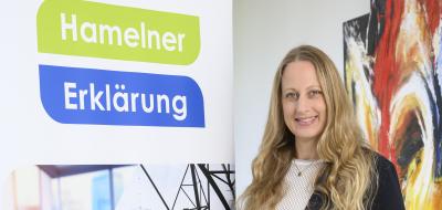 Eine Person steht neben einem Rollup-Poster