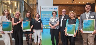 Persongruppe mit Urkunden in den Händen