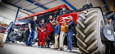 Gruppe von Personen in Halle mit Landmaschinen