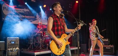 Drei Rockmusiker auf einer Bühne