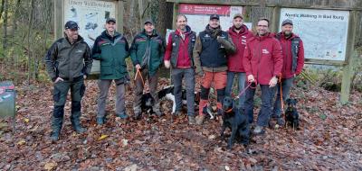 Personengruppe steht auf einer Waldlichtung
