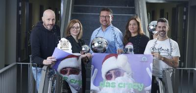 Fünf Personen mit Weihnachtsschmuck stehen in einem Treppenhaus.