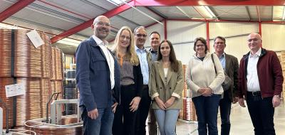 Eine Personengruppe steht in einer Lagerhalle.