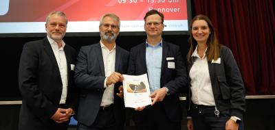 Vier Personen stehen auf einer Bühne.