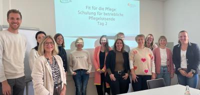 Eine Personengruppe vor eine Präsentationswand