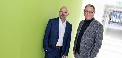 Zwei Personen stehen in einem Gebäudeflur.