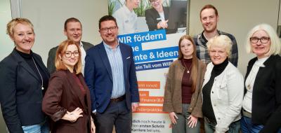 Gruppe von Personen vor Plakat